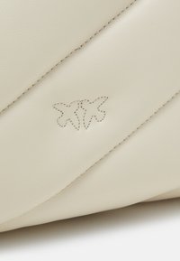 Witte leren tas met een diagonaal geruit ontwerp. Voorzien van een subtiele geborduurde logo. Gladde textuur met contrasterende draaddetails.