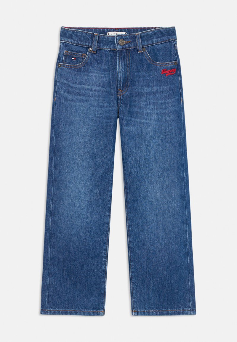 Vaqueros de denim azul con un diseño de pierna recta, que presentan costuras visibles y un pequeño logo rojo en el lado izquierdo. Textura levemente desgastada.