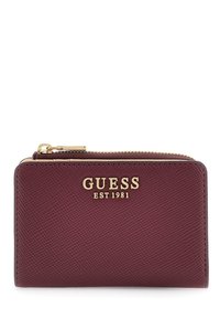 Cartera de cuero texturizado burdeos con cremallera dorada y el logotipo dorado "GUESS EST 1981" en la parte delantera.