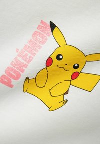 Gul bomullsstoff med et grafisk bilde av Pikachu, med r�øde kinn, svarte spisser på ørene, og teksten "POKÉMON" i rosa.