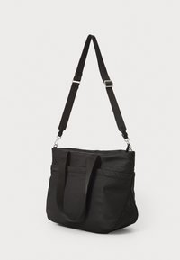 Sort tote bag med dobbelthåndtag og en justerbar skulderrem, der har en glat tekstur og en lynlås i toppen for sikker lukning.
