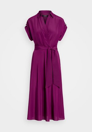Robe portefeuille violette à manches courtes, col et ceinture à la taille, avec poignets retroussés ornés d’un bouton.