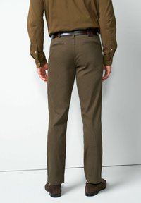 Bruine broek met slim fit en een subtiel ruitpatroon, gemaakt van een gladde stof. Zwarte riem met zilverkleurige gesp.