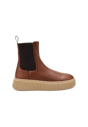 Bottine en cuir marron avec une semelle en caoutchouc beige à nervures, des panneaux latéraux élastiques noirs et une languette à l'arrière. Texture lisse et design épuré.