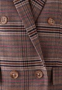 Dubbel gevoerd blazer met een bruin en beige ruitpatroon met accenten in rood en marineblauw, gemaakt van een textuurstof, met ronde knopen.