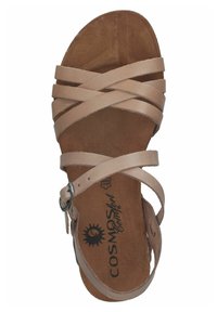 Strappy sandal with a beige leather upper. Features crisscrossed straps and an adjustable ankle strap. Brown textured insole.