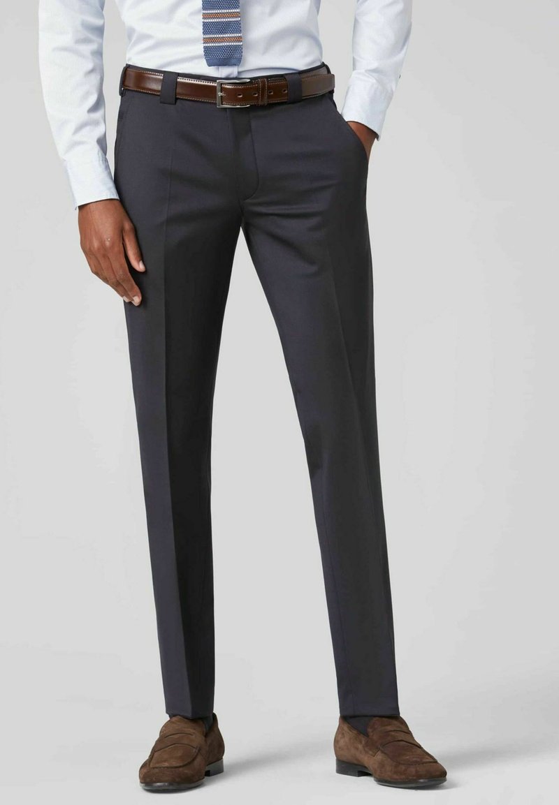 Marineblauwe dress trousers met een recht gesneden ontwerp, met een gladde textuur, riemlussen en subtiele plooi lijnen, gecombineerd met bruine suède schoenen.
