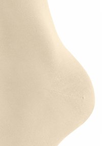 Beige Nylon Sock mit einer glatten Textur, ausgestattet mit einem nahtlosen Zehenbereich und einer engen Passform, die sich am Knöchel verjüngt.