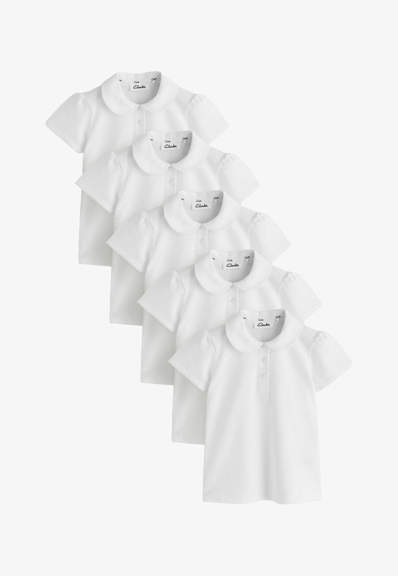 Cinq chemises blanches à manches courtes pour enfants avec col Claudine et boutons sur le devant, empilées en diagonale sur un fond blanc.
