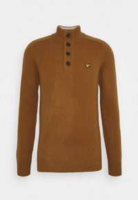 Bruine gebreide trui met een hoge kraag, vier zwarte knopen en een klein geel logo op de linkerborst. Gestructureerde stof met geribbelde manchetten.