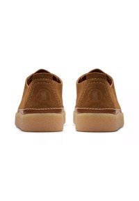 Scarpe in suede marrone con un design a trama bassa, contraddistinte da dettagli di cucitura e suole di gomma. La vista posteriore evidenzia il dettaglio del logo sul tallone.