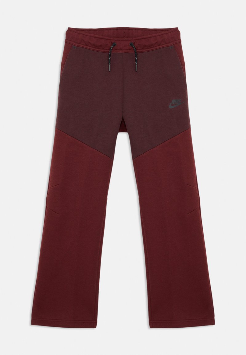 Calças de desporto em maroon, feitas de um tecido suave, com cintura ajustável por cordão, blocos de cor diagonais e um logo cinza da Nike na coxa.