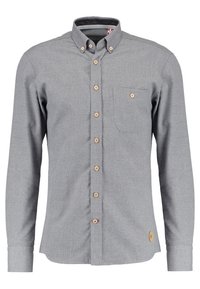 Camisa de botones gris con mangas largas, botones marrones, un bolsillo en el pecho y un parche con el logo en la parte inferior izquierda. Hecha de una tela texturizada.