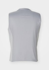 Haut sans manches gris avec une texture lisse, muni d'un col rond et d'une silhouette ajustée. Les panneaux latéraux dans une teinte plus claire créent un contraste.