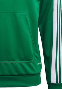 Sweat-shirt vert avec une poche avant, des poignets et trois bandes blanches sur le côté. Confectionné en tissu lisse et texturé.