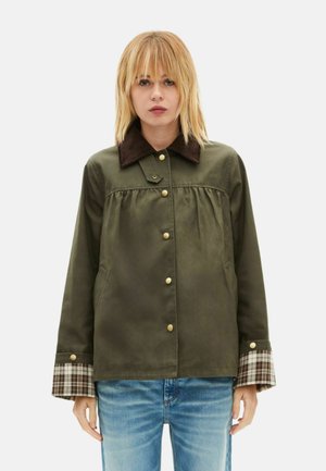 Kurtka oliwkowa z sztruksowym kołnierzem, złotymi guzikami i mankietami w kratę. Posiada luźny krój i marszczenie na wysokości biustu.