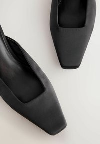 Schwarze Satin-High-Heels verfügen über ein quadratisches Zehendesign und eine glatte Textur mit einem offenen seitlichen Ausschnitt für Atmungsaktivität.