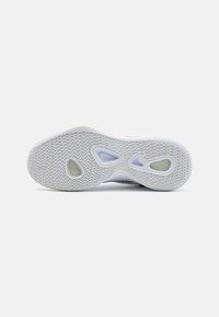 Hvid sneakersål med et struktureret mønster, der har udskårne sektioner og en gennemsigtig detalje i midten. Holdbart gummimateriale.