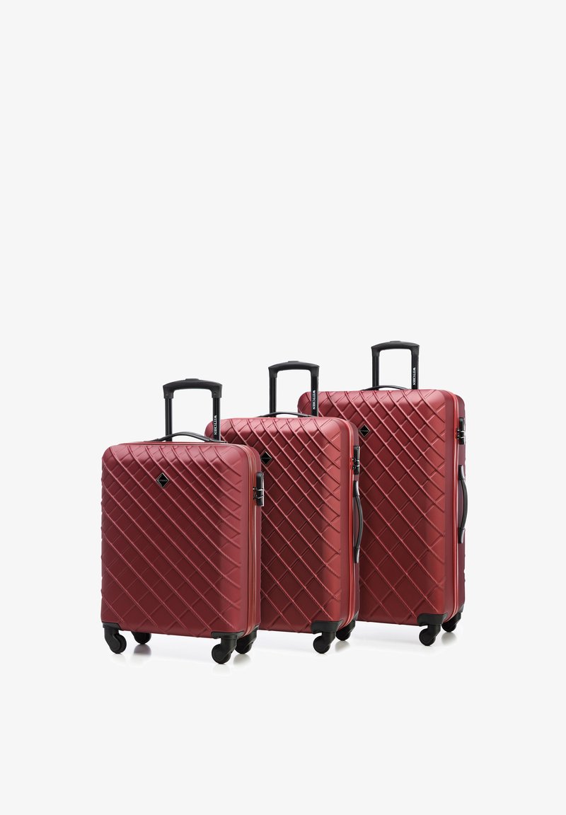 Tre valigie rigide color bordeaux di diverse dimensioni presentano un motivo a rombi, maniglie telescopiche nere e quattro ruote per la mobilità.
