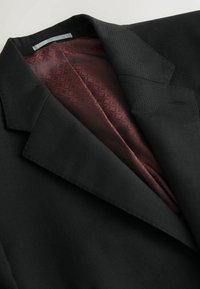 Black blazer with a notched collar and smooth texture, featuring a burgundy patterned lining visible inside. Subtle stitching details.