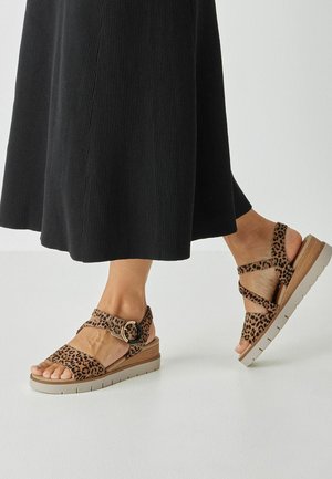 Sandalen mit Leopardenmuster und Plateau-Sohle, ausgestattet mit einem breiten Riemen, gekreuzten Bändern und einer runden Schnalle in neutraler Farbe.