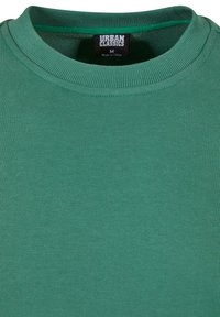 Felpa verde a girocollo realizzata in tessuto misto cotone. Presenta una texture a costine intorno al colletto e un'etichetta interna che indica la taglia M.