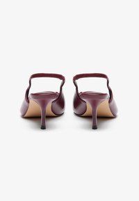Burgundin nahkainen slingback-korkokenkä, jossa on pieni stilettokorko. Teksturoitu pinta, avoin takapuu ja säädettävä nilkkaremmi.