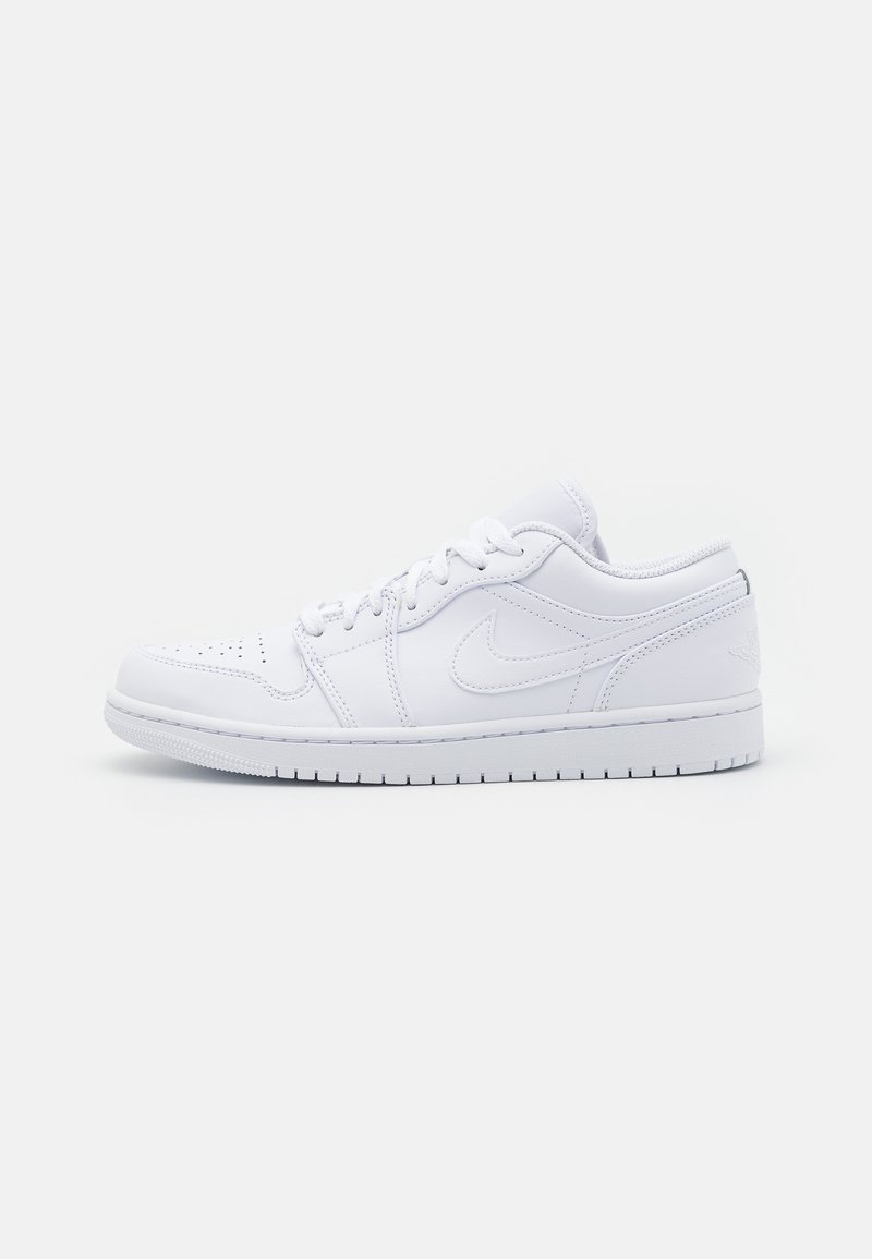 Baskets basses blanches Nike avec lacets, bout perforé et logo Nike visible sur le côté, vues depuis le côté extérieur.