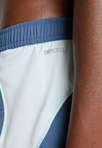 Herrers atletiska shorts med en dryCELL-tag. Designen innehåller en ljusblå och mörkblå färgskala med en strukturerad yta.