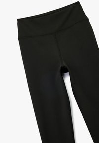 Czarne legginsy z elastycznego materiału z wysokim stanem, z płaskimi szwami i gładką fakturą, odpowiednie do aktywności fizycznej.