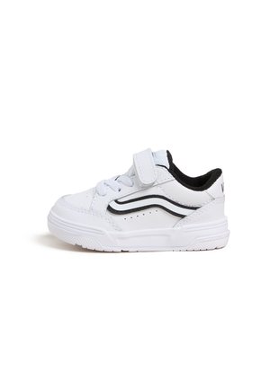 Biały sneaker dla malucha z czarnym falistym paskiem, zapinany na rzep, z sznurówkami i teksturowaną podeszwą na białym tle.