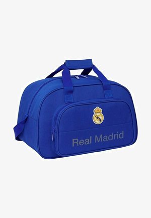 Niebieska torba sportowa z logo i napisem Real Madrid, podwójne uchwyty, przednia kieszeń na zamek i boczny pasek.