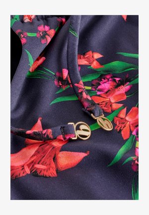 Tumesinise taustaga lillemustriga kangas, millel on erksad punased ja roosad lilled roheliste lehtedega. Kullast detailid reguleeritavate õlapaelte lähedal.