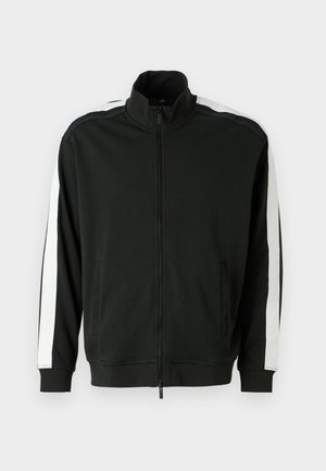 Jachetă neagră cu fermoar și guler înalt, decorată cu dungi albe pe mâneci și accente texturate. Fabricată dintr-un material moale, potrivit pentru îmbrăcăminte sportivă.