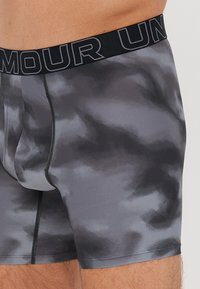 Graue Boxershorts mit cloud-artigem Muster, strukturiertem Stoff und einem schwarzen elastischen Bund mit geprägtem Branding.