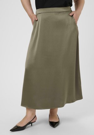Olive green midi skirt with a smooth texture, side pockets, and a waistband. Paired with black pointed-toe slingback heels.