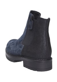 Marineblauwe suède chelsea boot met gestructureerd zwart zijpaneel, trekriem en chunky zwarte rubberen zool. Voorzien van een ronde neus en contrasterende stiksels.