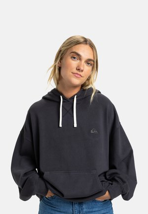 Dark gray oversized hoodie made of soft fabric. Features a drawstring hood, front pocket, and a small logo on the chest. White drawstrings.