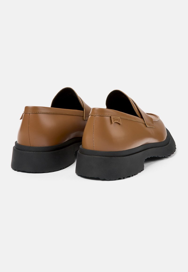Brązowe skórzane buty bez sznurówek o zaokrąglonym kształcie, czarna gumowa podeszwa i minimalne oznaczenia na pięcie, charakteryzujące się gładką teksturą.