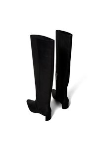 Botas altas hasta la rodilla de cuero negro con diseño ajustado, punta cuadrada y tacones bajos de bloque. Cuentan con una cremallera lateral para facilitar su uso.