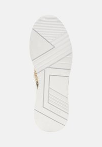 Suola di scarpa in gomma bianca con scanalature diagonali e orizzontali, caratterizzata da un motivo geometrico in rilievo e un logo del marchio stampato.