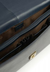 Navy leren tas met een gladde textuur, voorzien van een gouden sluiting, met rits afsluitbare compartimenten en een bruin stoffen voering met meerdere vakken.