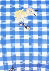 Tecido de gingham azul e branco com acentos florais amarelos e rosados. A textura parece suave e entrelaçada, com padrões de quadrados distintos.