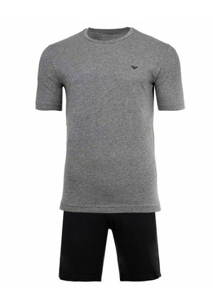 Camiseta gris de manga corta con cuello redondo y un pequeño logo negro en el pecho, combinada con pantalones cortos lisos negros.