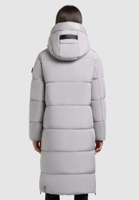 Lång pufferjacka i ljusgrått med horisontella quiltade sektioner, huva och en logotyp på baksidan. Slät, något glänsande textur.