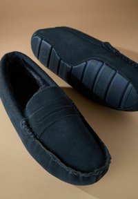 Pantofi albastru închis din suede, tip slip-on, cu o căptușeală moale, având cusături decorative și o talpă din cauciuc texturat pentru aderență.