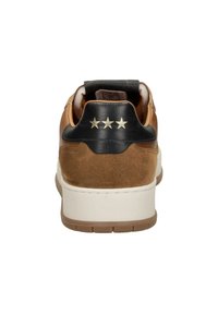 Rjavi nubuk teniški čevlji z črnim usnjenim petnim delom in tremi zlatimi zvezdami. Vsebujejo belo srednje podplat in gumijast podplat z svetlobnimi rjavimi akcenti.