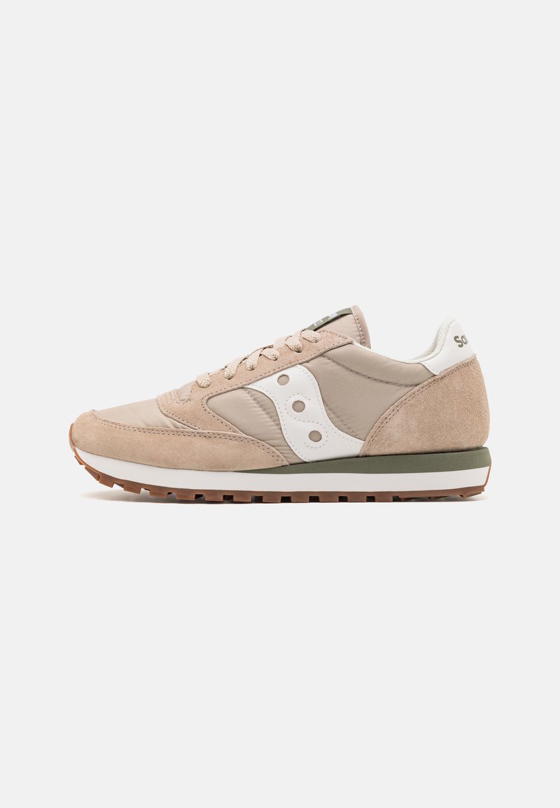 Sneaker med en beige og tan semsket overdel, hvite detaljer, flettede lisser og gummisåle. Har et teksturert design og en retro silhuett.