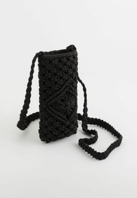 Black woven handbag made of textured fabric, featuring a knotted design and a braided strap, with a rectangular shape and open top.