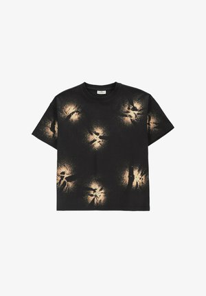 Czarny t-shirt z krótkim rękawem z beżowymi plamami wybielacza rozsianymi na przodzie, kołnierzu i rękawach.